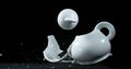 Tea-Pot falling and exploding on Black Background Royalty Free Stock Photo