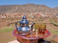 Tea pot with glasses on colorful tray, Ourika valley and High Atlas Mountains in the background. Morocco. Royalty Free Stock Photo
