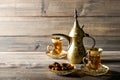 Tea pot glasses golden oriental decoration wooden background