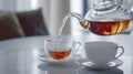 A tea pot pouring hot tea into a cup Royalty Free Stock Photo