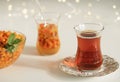 Tea with sea buckthorn berries and ginger. Glasses of armudu with useful herbal tea. Glass bowl with sea buckthorn berries. Close-