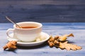 Tea served with spoon, sugar and decor as cinnamon. Mug filled with black brewed tea, spoon and autumn fallen leaves on Royalty Free Stock Photo