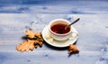 Tea served with spoon, sugar and decor as cinnamon. Mug filled with black brewed tea, spoon and autumn fallen leaves on Royalty Free Stock Photo