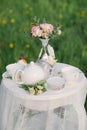A tea service, a delicate bouquet of roses and eustoma in a silver vase on a coffee table with a lace tablecloth. Wedding decor Royalty Free Stock Photo