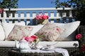 Tea-set and beautiful flowers on sunny terrace. A rattan patio set including a sofa. Royalty Free Stock Photo