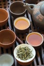 Tea set ceramic cups pot utensils on wooden bamboo dripping tray. Chinese Japanese ceremony. Freshly brewed beverage. Lifestyle