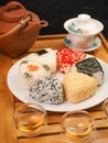 Tea set for the ceremony and Onigiri. Various shapes and fillings on a plate. Healthy snack. Japanese rice ball. Top view