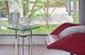 Tea set on glass top table with red easy chair in living room Royalty Free Stock Photo