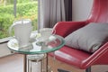 Tea set on glass top table with red easy chair in living room interior Royalty Free Stock Photo
