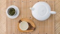 Tea set top view. Porcelain teapot, teacup and green tea in a metal filter on a bamboo tray Royalty Free Stock Photo