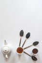 Tea set with white ceramic tea pot and other tea ingredients on the white. Flat lay view of various dried teas and teapot. View Royalty Free Stock Photo
