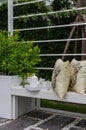 Tea set and yellow pillows on white bench