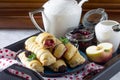 Tea and sliced home apple minischtrudel with fresh apples, cherries, blackberries and sugar powder on an antique wooden background