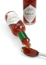 Tea Spoon with Tabasco, Hot Pepper Sauce, Bottle against White Background Royalty Free Stock Photo