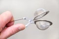 Tea strainer in hand close-up on a light background