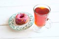 Tea and sugar donut on white wooden table Royalty Free Stock Photo