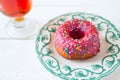 Tea and sugar donut on white wooden table Royalty Free Stock Photo