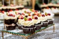 Tea table, a lot of beautiful, bright and delicious cupcakes-cupcakes with cream, strawberries Royalty Free Stock Photo