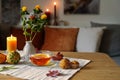 Tea time in autumn, glass cup, biscuits, pumpkins and candle on a table in a cozy home, copy space, selected focus