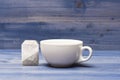 Tea time concept. Cup or white porcelain mug with transparent hot water and bag of tea. Mug filled with boiling water