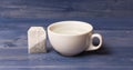 Tea time concept. Cup or white porcelain mug with transparent hot water and bag of tea. Process of tea brewing in