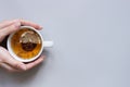 Tea time. Hands holding cup of hot black tea on the blue background, top view Royalty Free Stock Photo