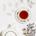 Cup of herbal tea, teapot and dry flowers on white background