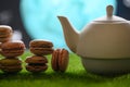 Tea time, oriental tales, teapot with French sweets, macaroons, starry sky and moon. Delicious and spicy tea with sweets, close-up