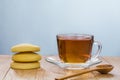 Tea in a transparent cup on a plate and cookies on a wooden table