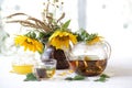 Tea in a transparent teapot, honey and sunflowers in a ceramic v