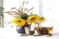 Tea in a transparent teapot and sunflowers in a ceramic vase