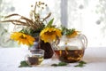 Tea in a transparent teapot and sunflowers in a ceramic vase