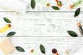 Tea tree spa composition. Fresh tea tree leaves, natural cosmetics, towel on white wooden background top view space for Royalty Free Stock Photo