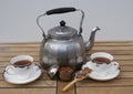 Tea for two prepared in an old aluminium water kettle with english tea cups as closeup