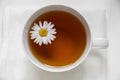 Tea in a white cup, chamomile floats, close up Royalty Free Stock Photo