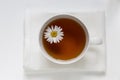 Tea in a white cup, chamomile floats, close up Royalty Free Stock Photo