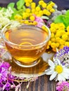 Tea from wild flowers in glass cup on board Royalty Free Stock Photo