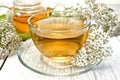 Tea with yarrow in cup on light board Royalty Free Stock Photo