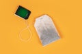 Teabag with green label. Isolated on yellow background Royalty Free Stock Photo