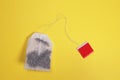 Teabag with red label on yellow background. copy space for text Royalty Free Stock Photo