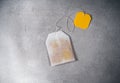 Teabag with yellow label on gray table. Top view of tea bag Royalty Free Stock Photo