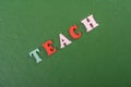 TEACH word on green background composed from colorful abc alphabet block wooden letters, copy space for ad text