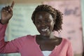 Teacher in Africa, smiling young woman shows students how to put up hands, Primary School, Uganda