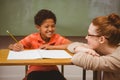 Teacher assisting boy with homework in classroom Royalty Free Stock Photo