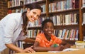 Teacher assisting boy with homework in library Royalty Free Stock Photo