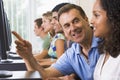 Teacher assisting college student on computers