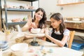 Teacher Assisting Girl To Unleash Her Creativity Of Pottery Pain
