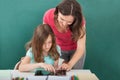 Teacher assisting girl in using digital tablet Royalty Free Stock Photo