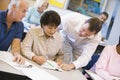 Teacher assisting mature student in class Royalty Free Stock Photo