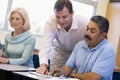 Teacher assisting mature student in class Royalty Free Stock Photo